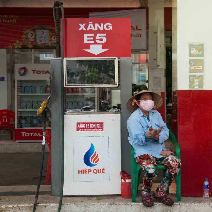 person sitting beside gasoline pump